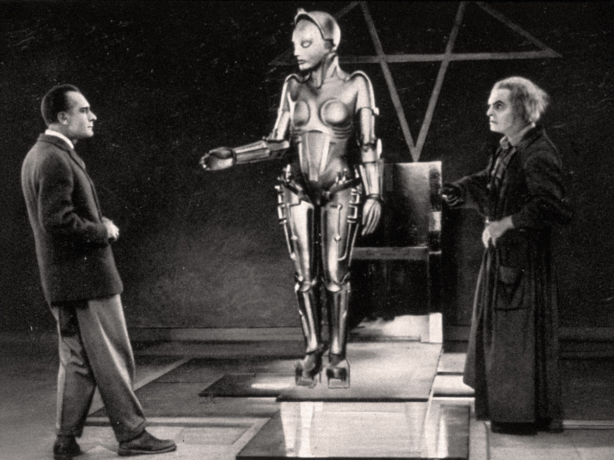 Cena icônica de Metrópolis (1927), de Fritz Lang: o cientista Rotwang e Freder diante da androide Maria, em um dos frames mais reconhecíveis da história do cinema. © Friedrich-Wilhelm-Murnau-Stiftung